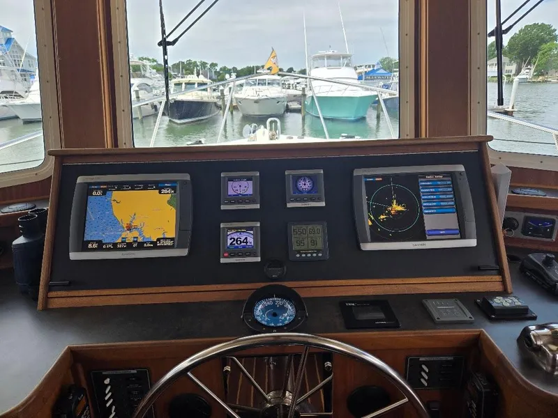Slide: The Image of Pilothouse of 2010 American Tug 49 Limited with leather seating and navigation equipment. - 8