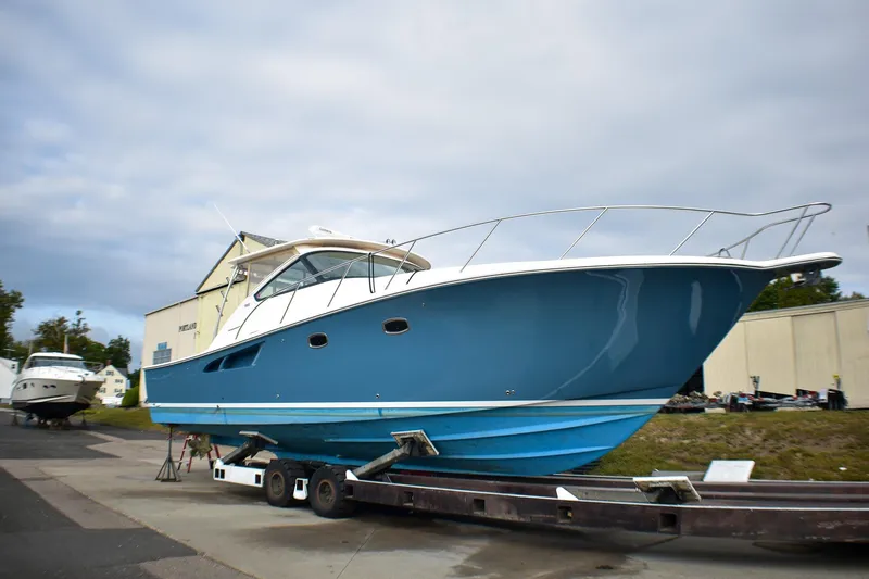 The Image of 2016 Tiara Yachts 4300 Open in blue, displayed on a trailer outdoors. - 0