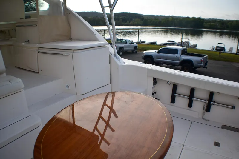 Slide: The Image of 2016 Tiara Yachts 4300 Open interior with wooden table, overlooking a serene waterfront. - 18