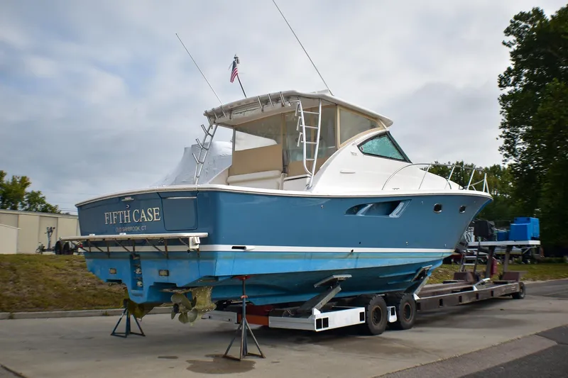 Slide: The Image of 2016 Tiara Yachts 4300 Open on trailer, blue hull, docked outdoors. - 4
