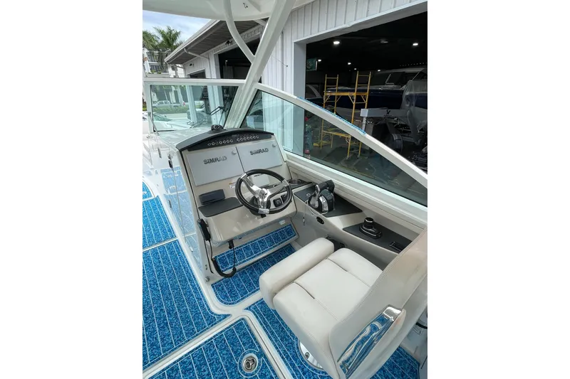 Slide: The Image of 2017 Boston Whaler 320 Vantage boat cockpit with steering wheel and Simrad electronics. - 12
