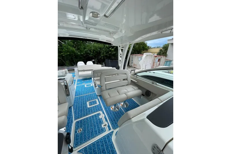 Slide: The Image of 2017 Boston Whaler 320 Vantage interior with blue flooring and cushioned seating. - 22