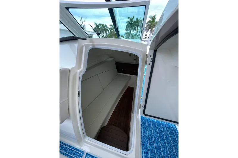 Slide: The Image of 2017 Boston Whaler 320 Vantage cabin interior with seating and wooden flooring. - 23