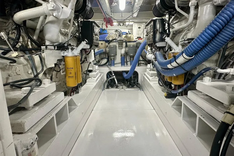 Slide: The Image of Engine room of 2000 Custom Carolina Precision Sportfish with visible machinery and blue hoses. - 10