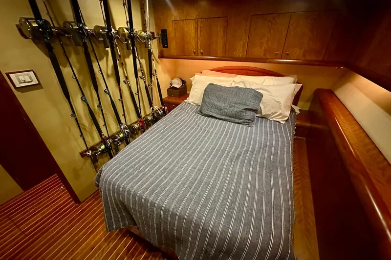 Slide: The Image of Cozy cabin interior of 2000 Custom Carolina Precision Sportfish with fishing rods and striped bedding. - 25