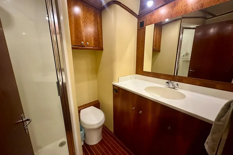 Slide: The Image of Luxurious bathroom in 2000 Custom Carolina Precision Sportfish yacht, featuring wood cabinetry and modern fixtures. - 29