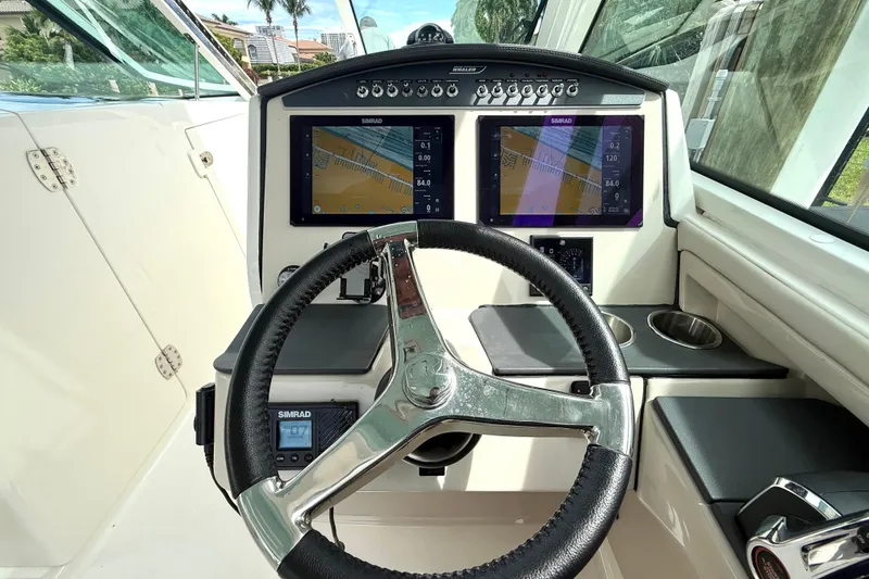 Slide: The Image of 2024 Boston Whaler 320 Vantage helm with dual Simrad displays and modern steering wheel. - 16