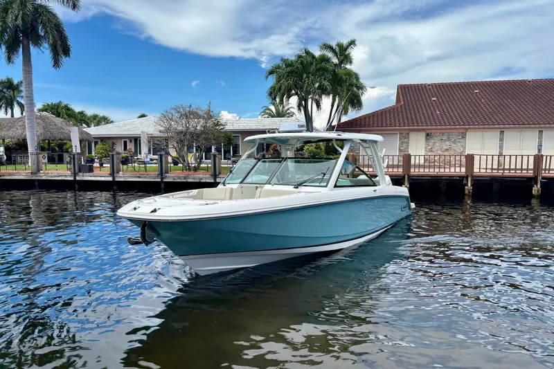 Slide: The Image of 2024 Boston Whaler 320 Vantage boat on water near waterfront homes. - 2
