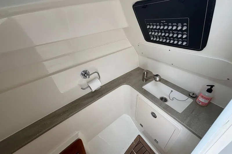 Slide: The Image of 2024 Boston Whaler 320 Vantage interior with sink, control panel, and storage. - 21