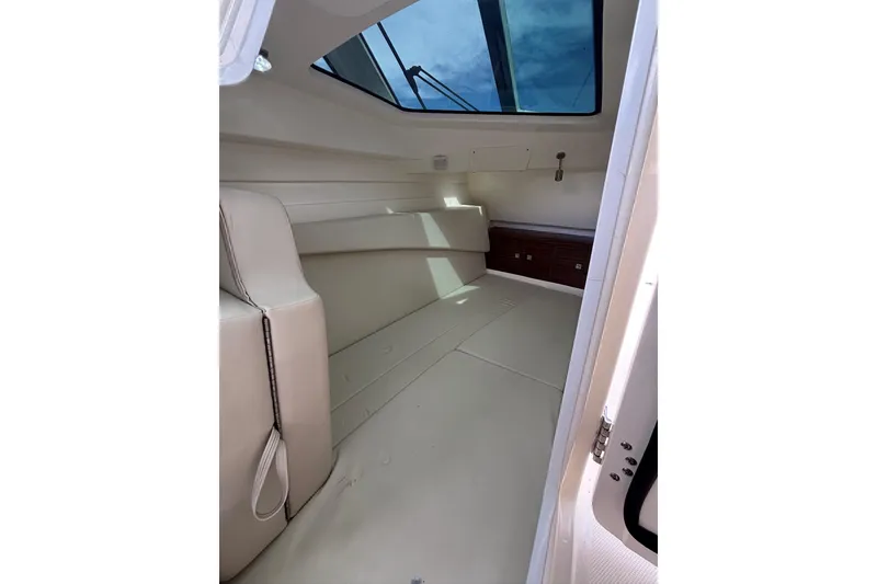 Slide: The Image of 2024 Boston Whaler 320 Vantage cabin interior with skylight and seating. - 22
