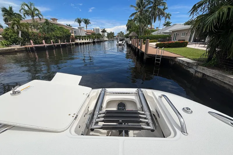 Slide: The Image of 2024 Boston Whaler 320 Vantage boat docked in a scenic canal setting. - 23