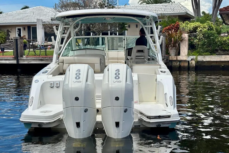 Slide: The Image of 2024 Boston Whaler 320 Vantage with dual 400 V10 engines docked by waterfront home. - 3