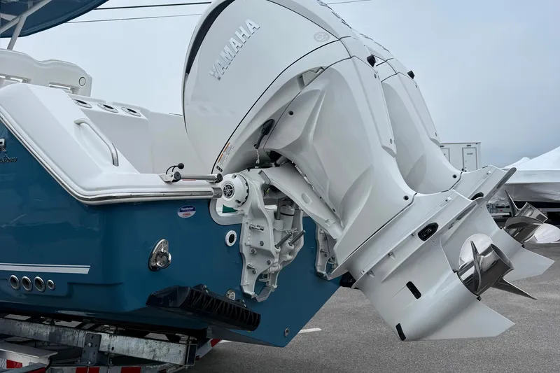 Slide: The Image of 2026 Tidewater 282 CC Adventure boat with dual outboard engines, parked in a lot. - 13