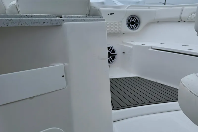 Slide: The Image of 2026 Tidewater 282 CC Adventure boat interior with seating, speakers, and countertop. - 21