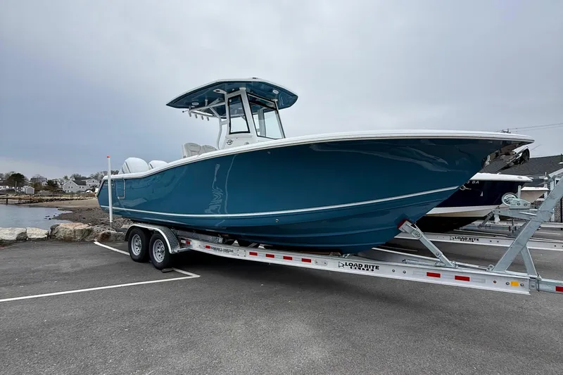 Slide: The Image of 2026 Tidewater 282 CC Adventure boat with Yamaha engine on trailer by rocky shore. - 4
