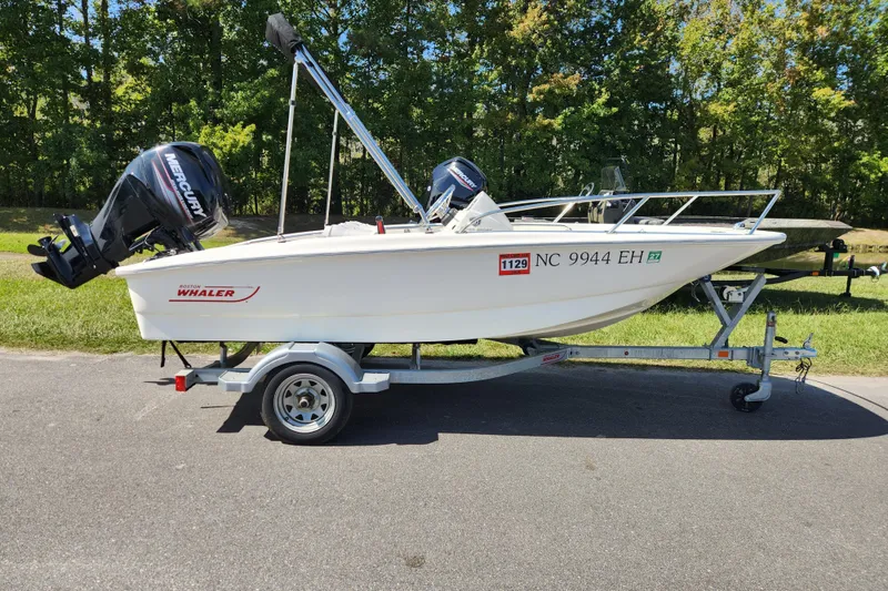The Image of 2018 Boston Whaler 130 Super Sport boat on trailer, parked outdoors. - 0