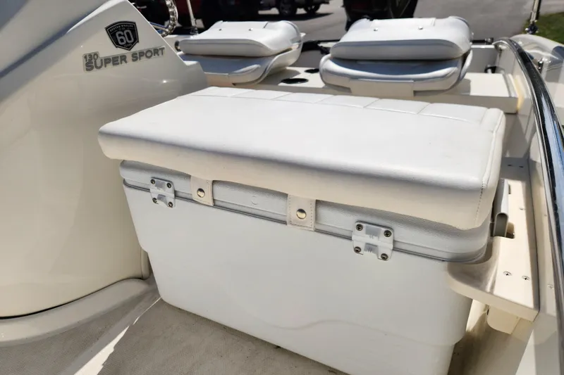 Slide: The Image of 2018 Boston Whaler 130 Super Sport interior with cushioned seating and storage. - 10