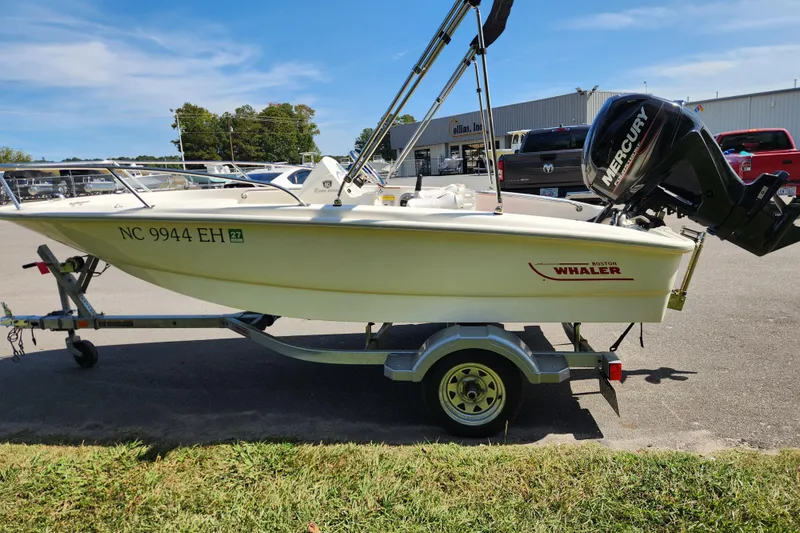 Slide: The Image of 2018 Boston Whaler 130 Super Sport boat on trailer, parked outdoors. - 4