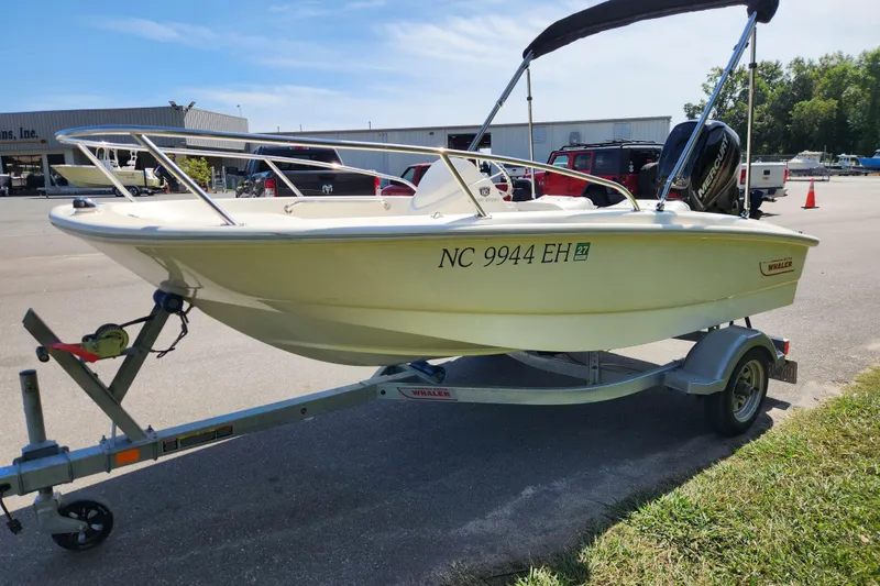 Slide: The Image of 2018 Boston Whaler 130 Super Sport boat on trailer in parking lot. - 5