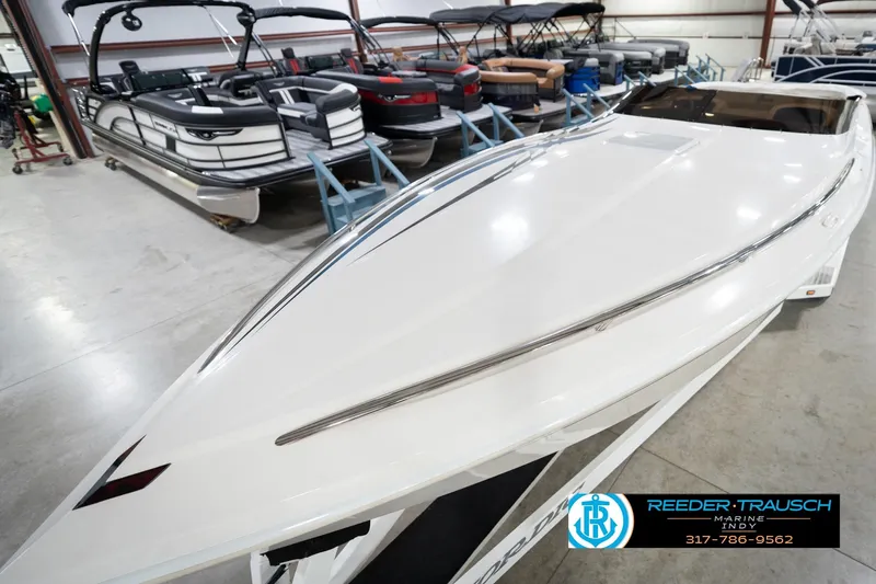 Slide: The Image of 2001 Nordic Heat 28 boat in showroom, sleek white design, surrounded by other boats. - 12