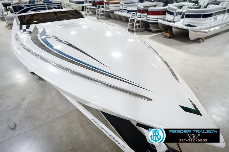 Slide: The Image of 2001 Nordic Heat 28 boat in showroom, sleek design with blue and black accents. - 13