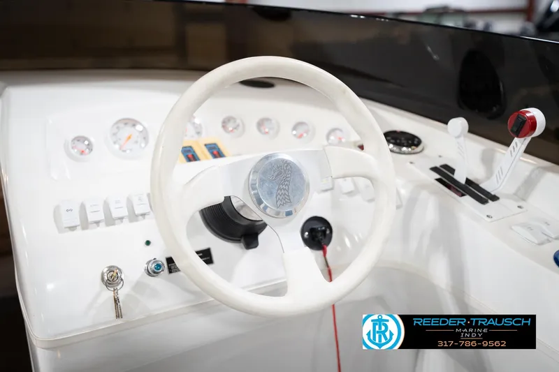 Slide: The Image of Steering wheel and controls of a 2001 Nordic Heat 28 boat dashboard. - 29