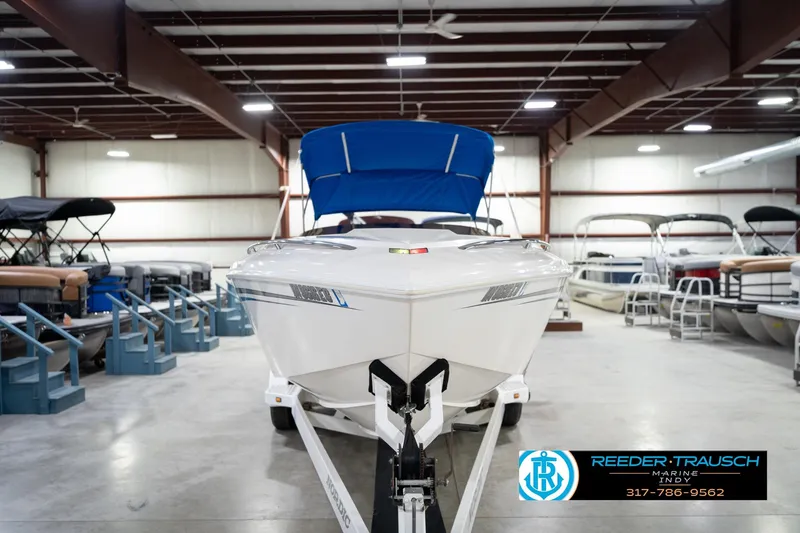 Slide: The Image of 2001 Nordic Heat 28 boat in showroom, featuring blue canopy and sleek design. - 5