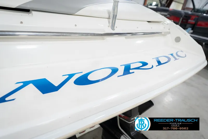Slide: The Image of 2001 Nordic Heat 28 boat with blue lettering, displayed indoors. - 55