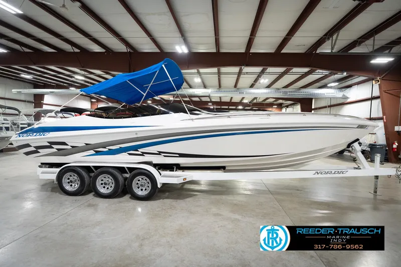 Slide: The Image of Nordic Heat 28 boat, 2001 model, with blue canopy on trailer in indoor showroom. - 7