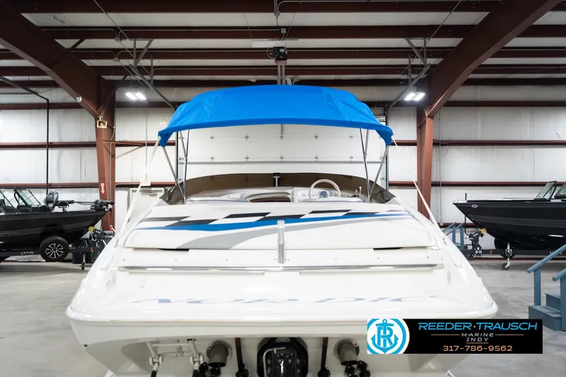 Slide: The Image of 2001 Nordic Heat 28 boat with blue canopy in indoor showroom. - 9