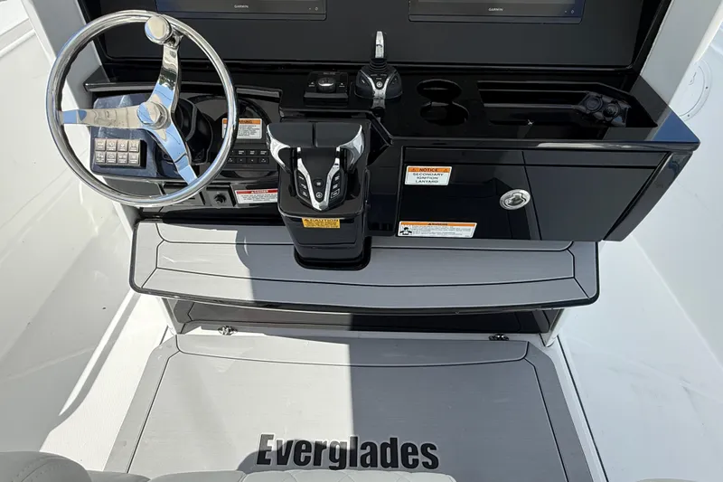 Slide: The Image of 2026 Everglades 335 Center Console boat helm with steering wheel and controls. - 32