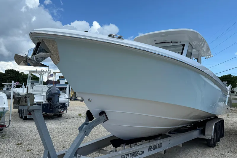 Slide: The Image of 2026 Everglades 335 Center Console boat on trailer, displayed outdoors under blue sky. - 8
