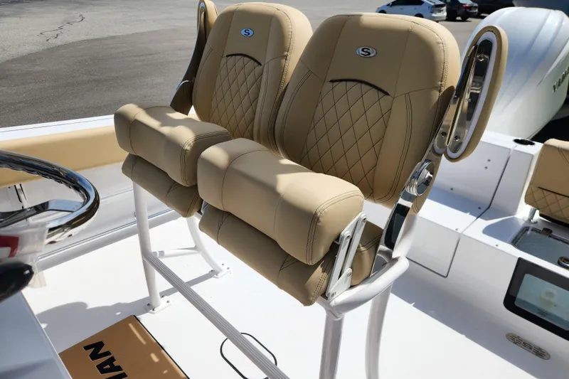 Slide: The Image of 2026 Sportsman Heritage 231 Center Console boat with tan cushioned seats and steering wheel. - 16