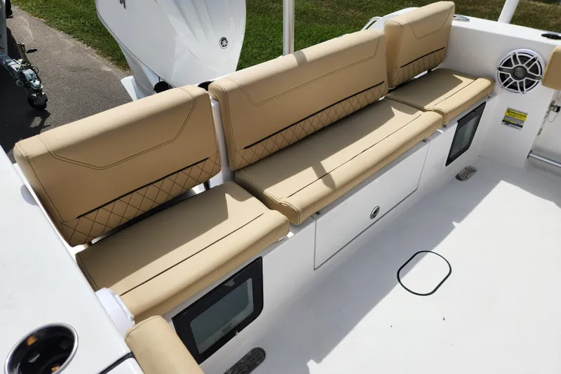 Slide: The Image of 2026 Sportsman Heritage 231 Center Console boat with tan cushioned seating and storage compartments. - 19