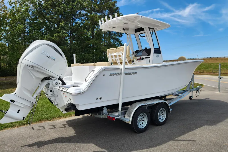 Slide: The Image of 2026 Sportsman Heritage 231 Center Console boat on trailer, parked outdoors. - 2