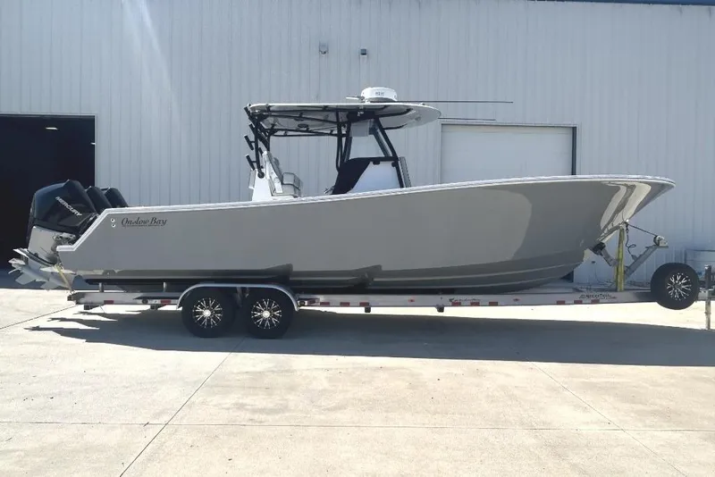 The Image of 2022 Onslow Bay 33 Tournament boat on trailer, parked outside a building. - 1
