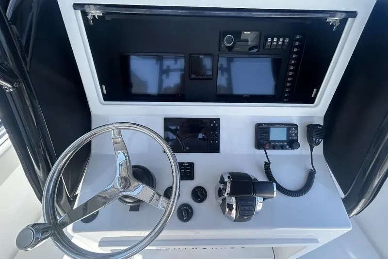 Slide: The Image of 2022 Onslow Bay 33 Tournament boat dashboard with steering wheel, controls, and navigation equipment. - 7