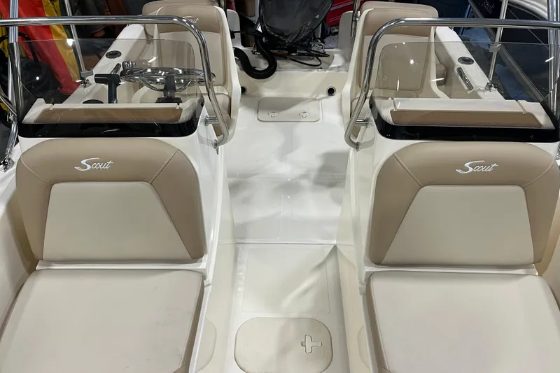 Slide: The Image of 2025 Scout 175 Sport Dorado boat interior with beige seating and dual consoles. - 12