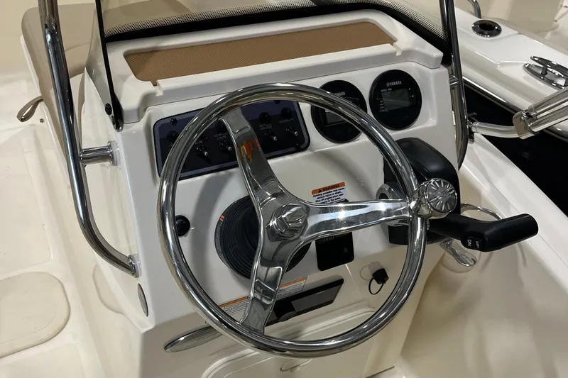 Slide: The Image of 2025 Scout 175 Sport Dorado boat steering console with chrome wheel and gauges. - 15