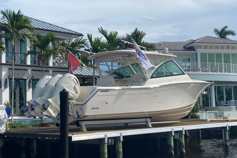 Slide: The Image of 2024 Grady-White Freedom 375 boat docked near luxury waterfront home. - 2