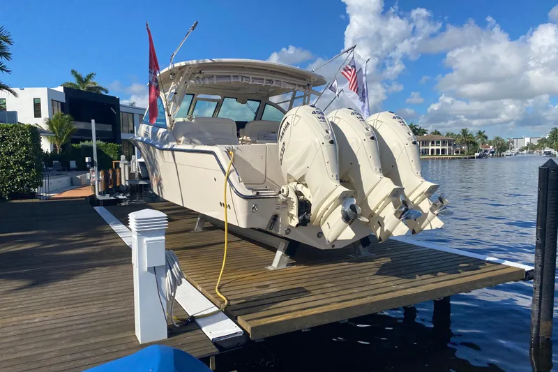 Slide: The Image of 2024 Grady-White Freedom 375 boat docked, featuring triple Yamaha outboard engines. - 26