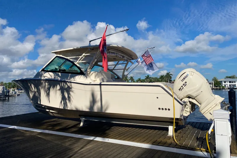 Slide: The Image of 2024 Grady-White Freedom 375 boat docked, featuring Yamaha engines, under a clear blue sky. - 4