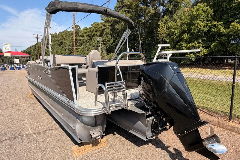 Slide: The Image of 2022 Avalon 2585 ENT Catalina Platinum pontoon boat with outboard motor, parked outdoors. - 5