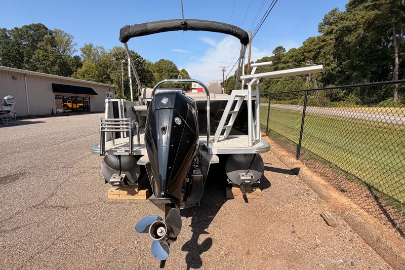 Slide: The Image of 2022 Avalon 2585 ENT Catalina Platinum pontoon boat with outboard motor, parked outdoors. - 6