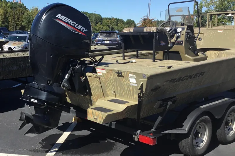 Slide: The Image of 2023 Tracker Grizzly 2072 CC Sportsman boat with Mercury outboard motor in a parking lot. - 10