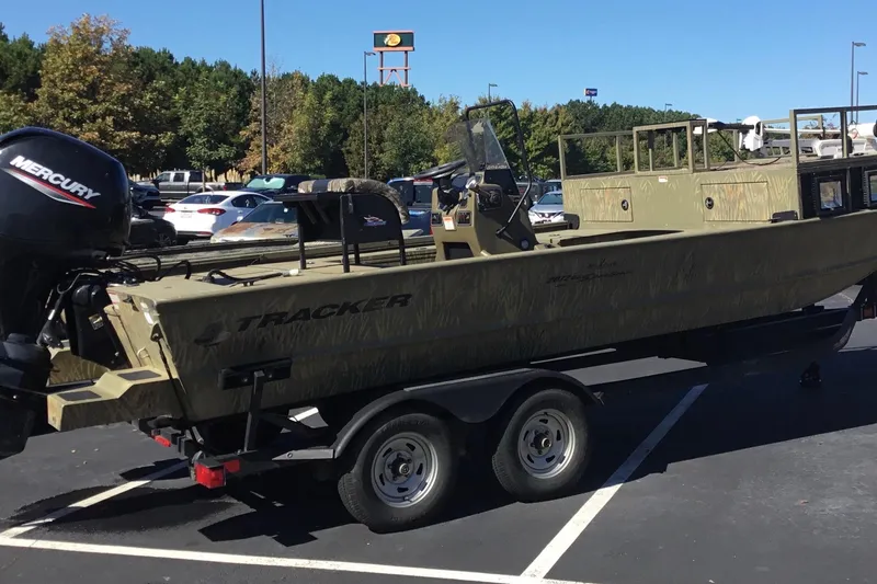 Slide: The Image of 2023 Tracker Grizzly 2072 CC Sportsman boat on trailer in parking lot. - 11