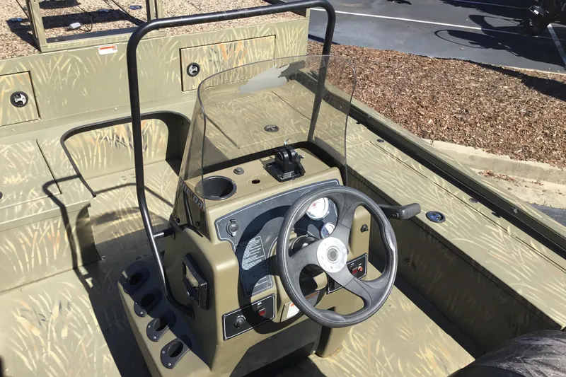 Slide: The Image of 2023 Tracker Grizzly 2072 CC Sportsman boat interior with steering console and camouflage design. - 4