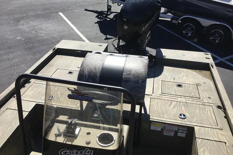Slide: The Image of 2023 Tracker Grizzly 2072 CC Sportsman boat with camouflage design and Mercury outboard motor. - 5