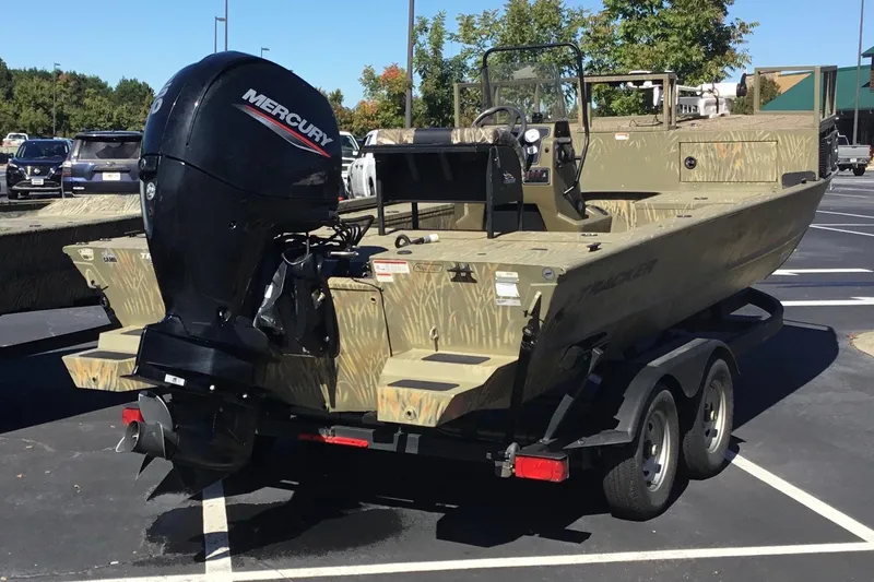 Slide: The Image of 2023 Tracker Grizzly 2072 CC Sportsman boat with Mercury outboard motor in a parking lot. - 9