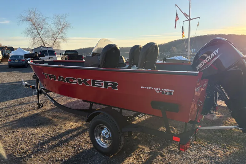 Slide: The Image of 2026 Tracker Pro Guide V-16 SC boat on trailer, red exterior, parked outdoors. - 79
